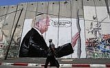 A Palestinian man walks past a graffiti depicting US President Donald Trump on the Israeli security barrier in the West Bank town of Bethlehem on August 4, 2017. (AFP/Musa Al Shaer)