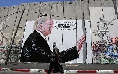 A Palestinian man walks past a graffiti depicting US President Donald Trump on the Israeli security barrier in the West Bank town of Bethlehem on August 4, 2017. (AFP/Musa Al Shaer) A Palestinian man walks past a graffiti depicting US President Donald Trump on the Israeli security barrier in the West Bank town of Bethlehem on August 4, 2017. (AFP/Musa Al Shaer)