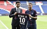 Brazilian superstar Neymar (R) poses with his jersey next to Paris Saint Germain's (PSG) Qatari president Nasser Al-Khelaifi during his official presentation at Paris' Parc des Princes stadium on August 4, 2017.
(AFP Photo/Philippe Lopez)