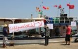 Tunisian fishermen hang banners as they gather on August 6, 2017 in the port of Zarzis in southeastern Tunisia to protest against a possible berthing of the C-Star vessel, hired by far-right activists from a group which calls itself 'Generation Identity' to prevent would-be migrants from reaching Europe. The writing in Arabic reads: 'No to Racism' (AFP PHOTO / FATHI NASRI)