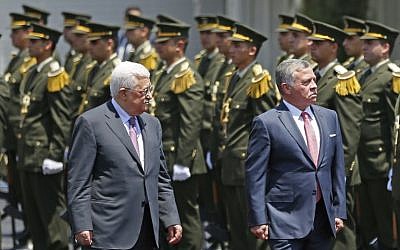 Jordan's King Abdullah II and Palestinian Authority President Mahmoud Abbas observe the honor guard during a visit in the West Bank city of Ramallah on August 7, 2017. (AFP PHOTO / ABBAS MOMANI)