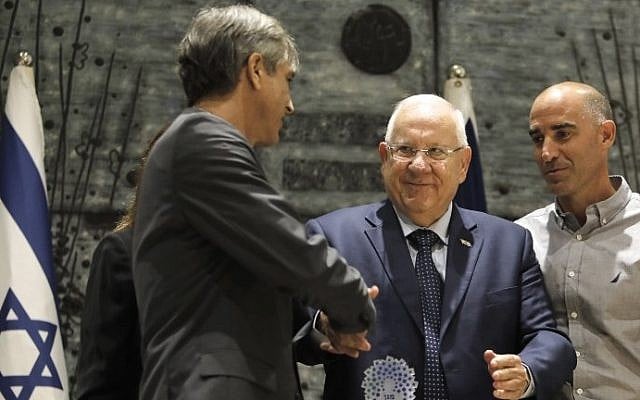 President Reuven Rivlin (C) presents the Shield of Honor prize to Eli Ohana (L), the chairman of Beitar Jerusalem soccer club, during a ceremony at the President's Residence in Jerusalem, on August 7, 2017. (AFP Photo/Menahem Kahana) President Reuven Rivlin (C) presents the Shield of Honor prize to Eli Ohana (L), the chairman of Beitar Jerusalem soccer club, during a ceremony at the President's Residence in Jerusalem, on August 7, 2017. (AFP Photo/Menahem Kahana)