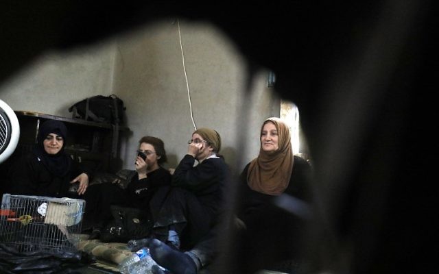 Members of an Armemian Christian family who fled from Raqqa sit near their pet parrots, "Lover" and "Beloved" in Jazra, a western suburb of Raqqa, on August 8, 2017, during battles to oust the Islamic State from the area. (AFP/Delil souleiman) Members of an Armemian Christian family who fled from Raqqa sit near their pet parrots, "Lover" and "Beloved" in Jazra, a western suburb of Raqqa, on August 8, 2017, during battles to oust the Islamic State from the area. (AFP/Delil souleiman)
