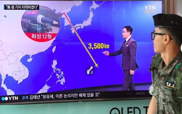 A South Korean soldier walks past a television screen showing a graphic of the distance between North Korea and Guam at a railway station in Seoul on August 9, 2017. (AFP Photo/Jung Yeon-Je) A South Korean soldier walks past a television screen showing a graphic of the distance between North Korea and Guam at a railway station in Seoul on August 9, 2017. (AFP Photo/Jung Yeon-Je)