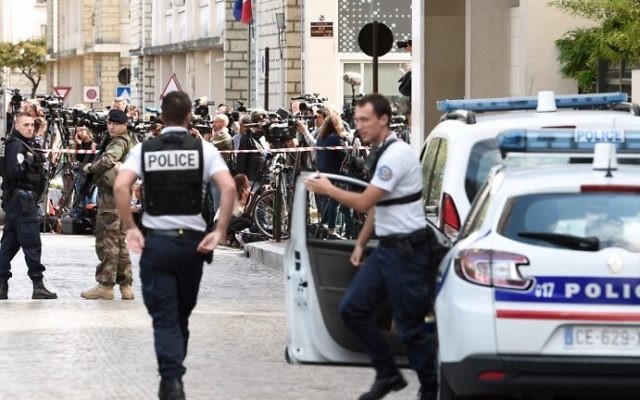 Journalists (back) gather behind a cordon as police work at the site where a car slammed into soldiers in Levallois-Perret, outside Paris, on August 9, 2017. (AFP PHOTO / STEPHANE DE SAKUTIN)