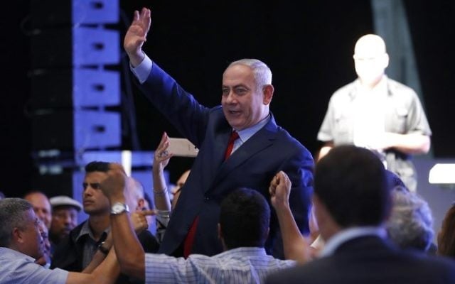 Prime Minister Benjamin Netanyahu waves to the crowd as he's surrounded by Likud party members and activists during a mass show of support at a gathering in the Tel Aviv Convention Center, August 9, 2017. (AFP/Jack Guez) Prime Minister Benjamin Netanyahu waves to the crowd as he's surrounded by Likud party members and activists during a mass show of support at a gathering in the Tel Aviv Convention Center, August 9, 2017. (AFP/Jack Guez)