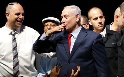 Prime Minister Benjamin Netanyahu, center, blows a kiss to the crowd as he's surrounded by activists during a gathering to show support for him as he face corruption investigations, held at the Tel Aviv Convention Center, August 9, 2017. (AFP/Jack GUEZ)