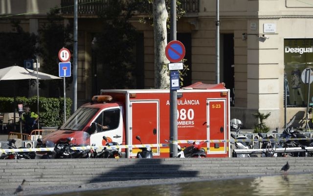A policeman stands next to an ambulance after a van plouwed into the crowd, on the Rambla in Barcelona on August 17, 2017. (AFP PHOTO / Josep LAGO) A policeman stands next to an ambulance after a van plouwed into the crowd, on the Rambla in Barcelona on August 17, 2017. (AFP PHOTO / Josep LAGO)