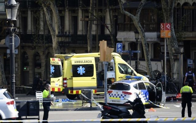 A policemen and a medical staff member stand near police cars and an ambulance in a cordoned off area after a van plowed into the crowd, on the Rambla in Barcelona on August 17, 2017. (AFP PHOTO / Josep LAGO) A policemen and a medical staff member stand near police cars and an ambulance in a cordoned off area after a van plowed into the crowd, on the Rambla in Barcelona on August 17, 2017. (AFP PHOTO / Josep LAGO)