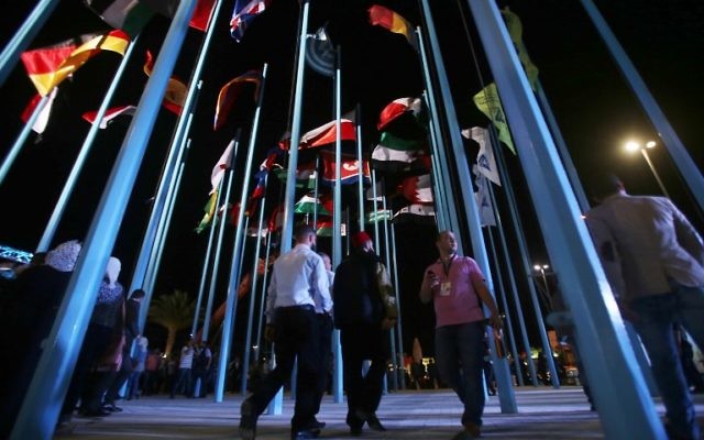Participants and visitors walk past flags of various countries during the opening of the Damascus International Fair late on August 17, 2017, in the Syrian capital. (AFP/Youssef KARWASHAN) Participants and visitors walk past flags of various countries during the opening of the Damascus International Fair late on August 17, 2017, in the Syrian capital. (AFP/Youssef KARWASHAN)