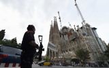 Police officers stand guard in front of the "Sagrada Familia" basilica in Barcelona on August 19, 2017.  (AFP / LLUIS GENE)
