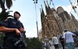 A police officer stands by the Sagrada Familia basilica in Barcelona on August 20, 2017, before a mass to commemorate victims of two devastating terror attacks in Barcelona and Cambrils. (AFP PHOTO / PASCAL GUYOT)