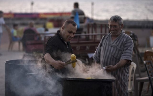 A Palestinian street vendor sells corn near the beach of Gaza City, on August 20, 2017. (AFP/Mahmud Hams) A Palestinian street vendor sells corn near the beach of Gaza City, on August 20, 2017. (AFP/Mahmud Hams)