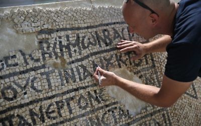 An archaeologist works on part of a 1,500-year-old mosaic floor bearing the names of Byzantine Emperor Justinian, at the Rockefeller Museum in Jerusalem, on August 23, 2017 (AFP PHOTO / AHMAD GHARABLI)