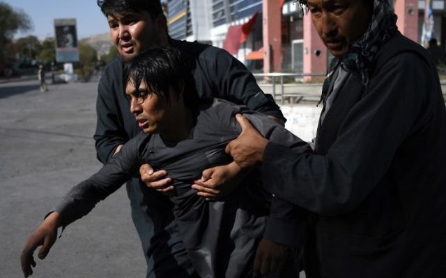 Afghan Shiite men carry a wounded friend near the site of suicide attack that targeted a Shiite mosque in Kabul on August 25, 2017. (AFP/Wakil Kohsar) Afghan Shiite men carry a wounded friend near the site of suicide attack that targeted a Shiite mosque in Kabul on August 25, 2017. (AFP/Wakil Kohsar)