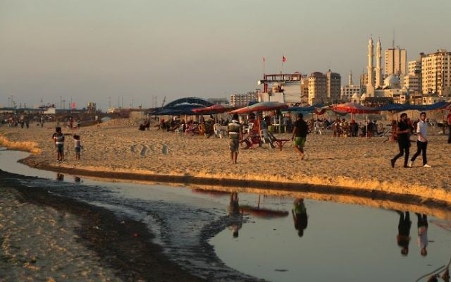 Palestinians spend time next to sewage-polluted waters on a beach in Gaza City on July 3, 2017. (AFP Photo/Mahmud Hams) Palestinians spend time next to sewage-polluted waters on a beach in Gaza City on July 3, 2017. (AFP Photo/Mahmud Hams)