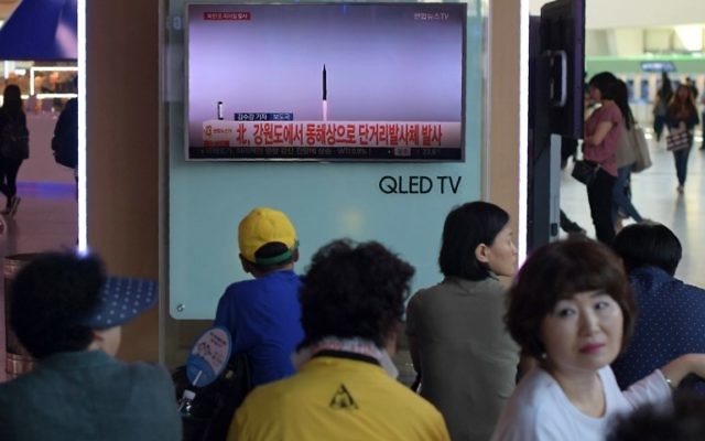 People are seen past a television screen showing file news footage of a North Korean missile launch, at a railway station in Seoul on August 26, 2017. (AFP/Ed Jones) People are seen past a television screen showing file news footage of a North Korean missile launch, at a railway station in Seoul on August 26, 2017. (AFP/Ed Jones)