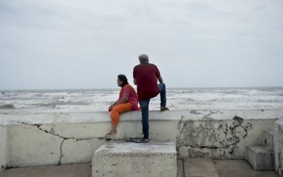 People look out from a seawall to the Gulf of Mexico as the effects of Hurricane Henry are seen August 26, 2017 in Galveston, Texas (AFP PHOTO / Brendan Smialowski)