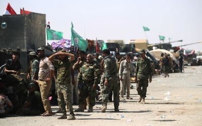 Fighters of Hashed Al-Shaabi (Popular Mobilization units) gather at the Tal Afar airport, west of Mosul, as Iraqi forces backed by local militia and a US-led coalition advanced in driving the Islamic State group from the city, on August 27, 2017. (AFP Photo/Ahmad al-Rubaye)