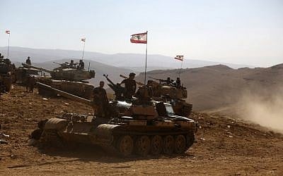 A picture taken on an army-organized press tour shows Lebanese army soldiers with the 6th Brigade standing on tanks flying the Lebanese flag in an area they recently took from the Islamic State (IS) group on the Syrian-Lebanese border, August 28, 2017. (AFP/PATRICK BAZ)