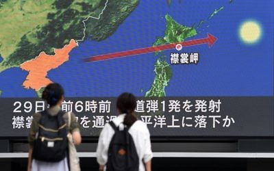 Pedestrians watch the news on a huge screen displaying a map of Japan (R) and the Korean Peninsula, in Tokyo on August 29, 2017, following a North Korean missile test that passed over Japan (AFP PHOTO / Toshifumi KITAMURA)