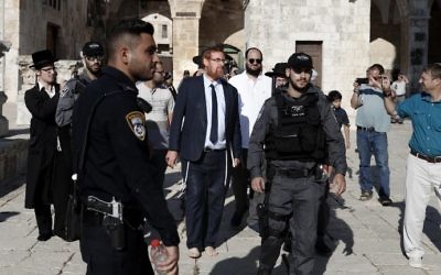 MK Yehuda Glick (C-L) walks barefoot, escorted by Israeli police and supporters, inside the flash-point Temple Mount complex in Jerusalem's Old City on August 29, 2017. (Ahmad Gharabli/AFP)