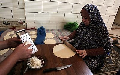 This photo taken on August 3, 2017 shows a Palestinian woman preparing bread during the few hours of mains electricity supply they receive every day, at Rafah refugee camp in the southern Gaza Strip. (AFP PHOTO / SAID KHATIB)