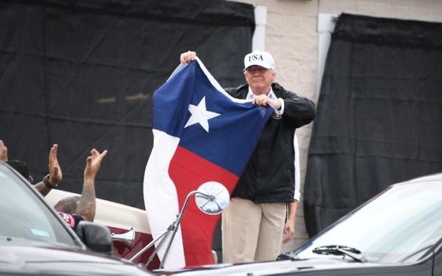 US President Donald Trump holds the state flag of Texas outside of the Annaville Fire House after attending a briefing on Hurricane Harvey in Corpus Christi, Texas on August 29, 2017. (AFP/ JIM WATSON) US President Donald Trump holds the state flag of Texas outside of the Annaville Fire House after attending a briefing on Hurricane Harvey in Corpus Christi, Texas on August 29, 2017. (AFP/ JIM WATSON)