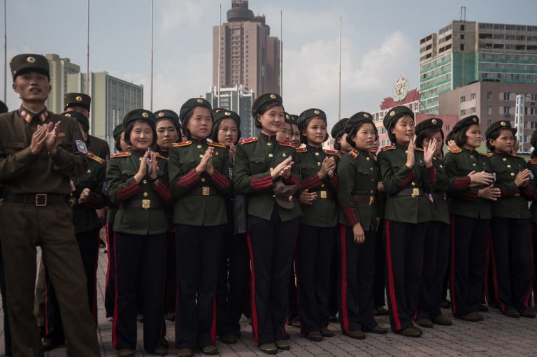 Korean People's Army (KPA) soldiers applaud as they watch a screen showing news coverage of an August 29 missile test launch, in a public square outside a train station in Pyongyang on August 30, 2017. North Korea leader Kim Jong-Un has promised more missile flights over Japan, insisting his nuclear-armed nation's provocative launch was a mere "curtain-raiser", in the face of UN condemnation and US warnings of severe repercussions. / AFP PHOTO / KIM Won-Jin