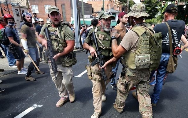 White nationalist militamen evacuate protesters who were pepper sprayed after the "Unite the Right" rally was declared a unlawful gathering by Virginia State Police August 12, 2017 in Charlottesville, Virginia. (Chip Somodevilla/Getty Images/AFP) White nationalist militamen evacuate protesters who were pepper sprayed after the "Unite the Right" rally was declared a unlawful gathering by Virginia State Police August 12, 2017 in Charlottesville, Virginia. (Chip Somodevilla/Getty Images/AFP)