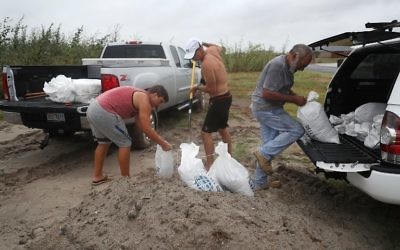 Cody Munds, Lee Martin and John Pezzi (L-R) fill sandbags as people prepare for approaching Hurricane Harvey on August 25, 2017 in Corpus Christi, Texas. (Joe Raedle/Getty Images/AFP)