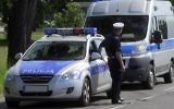Illustrative photo of a Polish police officer, accompanied by two service vehicles, performing spot checks on passing traffic. (GFDL Cezary p/Wikipedia)