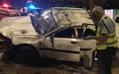 A police officer inspects the scene of a fatal car crash on Route 75, outside Nazareth on August 13, 2017. (Police spokesperson)