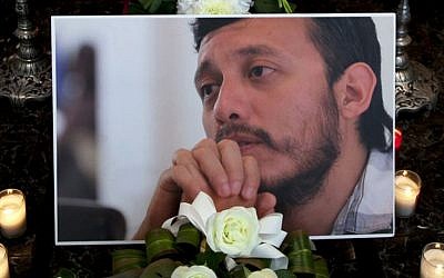 In this Aug. 3, 2015 file photo, a photograph of murdered photojournalist Ruben Espinosa sits among flowers and candles in front of his casket inside a funeral home before his wake begins in Mexico City.  (AP/Marco Ugarte, File)