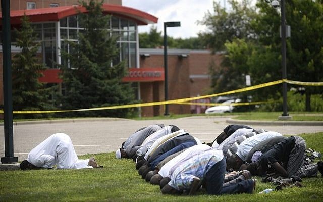 Mohamed Omar, left, the executive director of the Dar Al Farooq Center Islamic Center leads afternoon prayers outside the police tape surrounding the center Saturday Aug. 5, 2017 in Bloomington, Minn. (Aaron Lavinsky/Star Tribune via AP) Mohamed Omar, left, the executive director of the Dar Al Farooq Center Islamic Center leads afternoon prayers outside the police tape surrounding the center Saturday Aug. 5, 2017 in Bloomington, Minn. (Aaron Lavinsky/Star Tribune via AP)