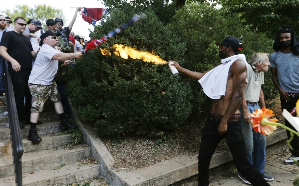 A counter demonstrator uses a lighted spray can against a white nationalist demonstrator at the entrance to Lee Park in Charlottesville, Va., Saturday, Aug. 12, 2017. (AP Photo/Steve Helber) A counter demonstrator uses a lighted spray can against a white nationalist demonstrator at the entrance to Lee Park in Charlottesville, Va., Saturday, Aug. 12, 2017. (AP Photo/Steve Helber)