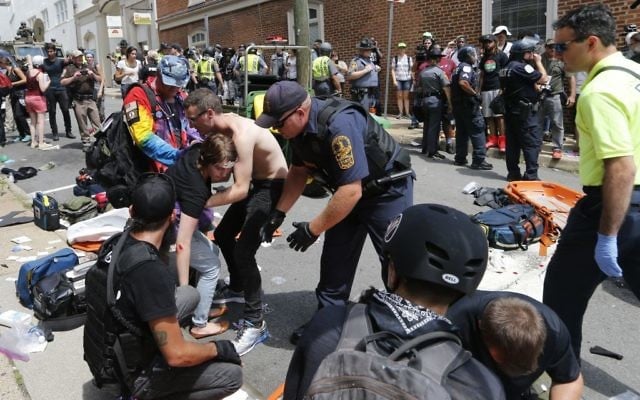 Rescue personnel help injured people after a car ran into a large group of protesters after a white nationalist rally in Charlottesville, Virginia, August 12, 2017. (AP Photo/Steve Helber) Rescue personnel help injured people after a car ran into a large group of protesters after a white nationalist rally in Charlottesville, Virginia, August 12, 2017. (AP Photo/Steve Helber)
