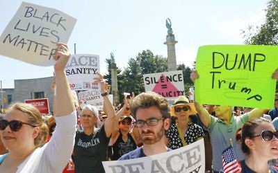Protesters listen during a "Peace and Sanity" rally Sunday Aug. 13, 2017, in New York, as speakers address white supremacy violence in Charlottesville, Va., yesterday. (AP/Bebeto Matthews)