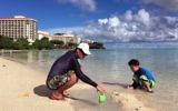 Kenji Kikuchi plays with his son Hideki in Ypao Beach, Tumon, Guam Monday, Aug. 14 2017. (AP Photo/Grace Bordallo)