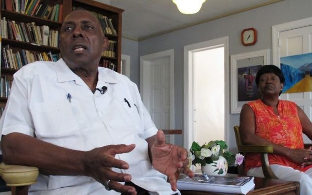 In this Wednesday, Aug. 16, 2017 photo, the Rev. Nelson Johnson and his wife, Joyce, talk about the 1979 'Greensboro Massacre' at his Faith Community Church in Greensboro, N.C. Johnson still has a faded scar on his left arm, left by a Nazi who attacked him. (AP Photo/Allen G. Breed) In this Wednesday, Aug. 16, 2017 photo, the Rev. Nelson Johnson and his wife, Joyce, talk about the 1979 'Greensboro Massacre' at his Faith Community Church in Greensboro, N.C. Johnson still has a faded scar on his left arm, left by a Nazi who attacked him. (AP Photo/Allen G. Breed)