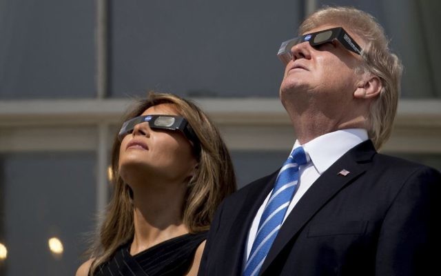 US President Donald Trump and First Lady Melania Trump wear protective glasses as they view the solar eclipse, Monday, Aug. 21, 2017, at the White House in Washington. (AP Photo/Andrew Harnik)