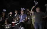 Menny Naftali, center, and Eldad Yaniv, far right, the main organizers of a weekly protest against Prime Minister Benjamin Netanyahu, in front of the home of Attorney General Avichai Mandelblit in Petah Tikva, August 26, 2017.  (AP Photo/Dan Balilty)