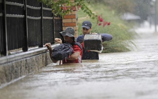 Residents wade through floodwaters from Tropical Storm Harvey, August 27, 2017, in Houston, Texas. (AP Photo/David J. Phillip) Residents wade through floodwaters from Tropical Storm Harvey, August 27, 2017, in Houston, Texas. (AP Photo/David J. Phillip)