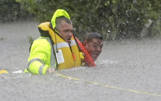 Wilford Martinez, right, is rescued from his flooded car by Harris County Sheriff's Department Richard Wagner along Interstate 610 in floodwaters from Tropical Storm Harvey , August 27, 2017, in Houston, Texas. (AP Photo/David J. Phillip) Wilford Martinez, right, is rescued from his flooded car by Harris County Sheriff's Department Richard Wagner along Interstate 610 in floodwaters from Tropical Storm Harvey , August 27, 2017, in Houston, Texas. (AP Photo/David J. Phillip)