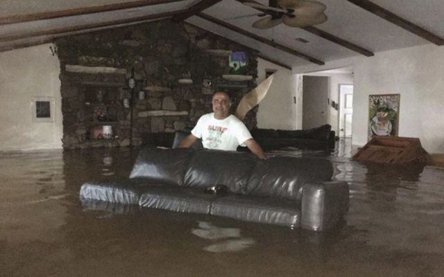 This Sunday, August 27, 2017, photo provided by Ramit Plushnick-Masti, shows her husband, Rafi, standing in waist-high water inside their flooded home in Houston's Meyerland neighborhood that was caused by Tropical Storm Harvey.  (Ramit Plushnick-Masti via AP)