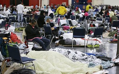 People rest at the George R. Brown Convention Center that has been set up as a shelter for evacuees escaping the floodwaters from Tropical Storm Harvey in Houston on Tuesday, Aug. 29, 2017. (AP Photo/LM Otero)