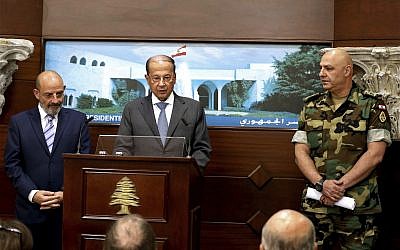 In this photo released by Lebanon's official government photographer Dalati Nohra, Lebanese Army Commander Gen. Joseph Aoun, right, and Spanish Defense Minister Yacoub Sarraf, left, listen to Lebanese President Michel Aoun, speaking to journalists at the Presidential Palace in Baabda, east of Beirut, Lebanon, Wednesday, Aug. 30, 2017. (Dalati Nohra via AP)