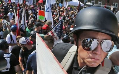 A white nationalist demonstrator with a helmet and shield walks into Lee Park in Charlottesville, Virginia. Hundreds of people chanted, threw punches, hurled water bottles and unleashed chemical sprays on each other, after violence erupted at a white nationalist rally in Virginia, on August 12, 2017. (AP Photo/Steve Helber)