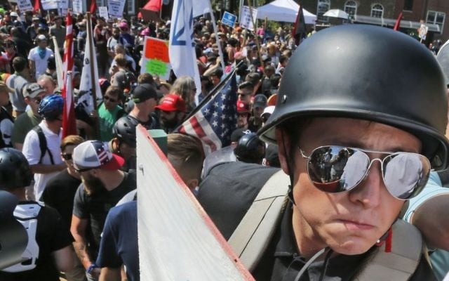 A white nationalist demonstrator with a helmet and shield walks into Lee Park in Charlottesville, Virginia. Hundreds of people chanted, threw punches, hurled water bottles and unleashed chemical sprays on each other, after violence erupted at a white nationalist rally in Virginia, on August 12, 2017. (AP Photo/Steve Helber)