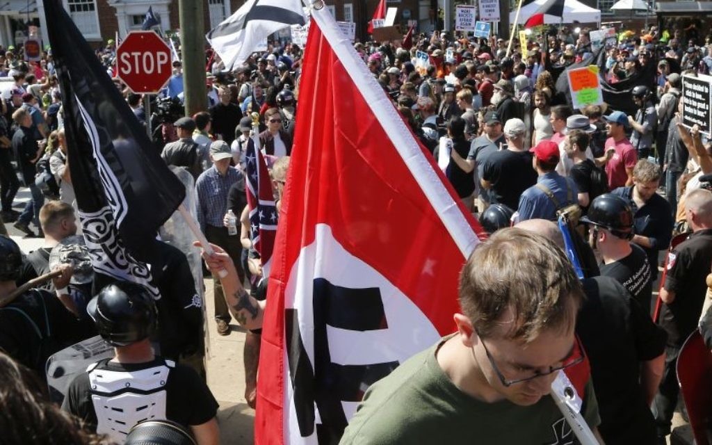 Illustrative: A white supremacist carrying a Nazi flag into Emancipation Park in Charlottesville, Virginia, on August 12, 2017. (AP/Steve Helber/File) Illustrative: A white supremacist carrying a Nazi flag into Emancipation Park in Charlottesville, Virginia, on August 12, 2017. (AP/Steve Helber/File)